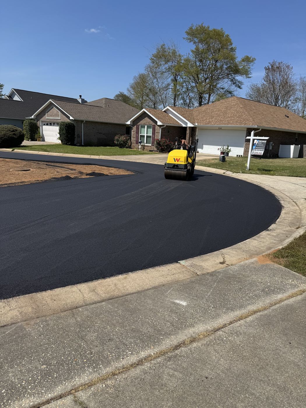 Roller compacting fresh asphalt on a neighborhood street